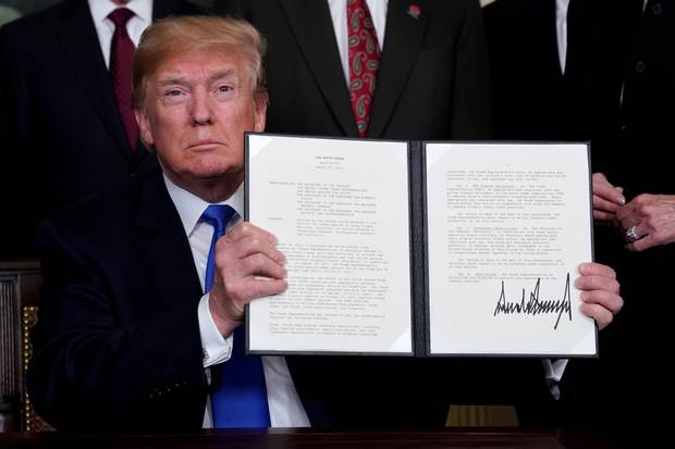 U.S. President Donald Trump holds his signed memorandum on intellectual property tariffs on high-tech goods from China, at the White House in Washington, March 22, 2018.