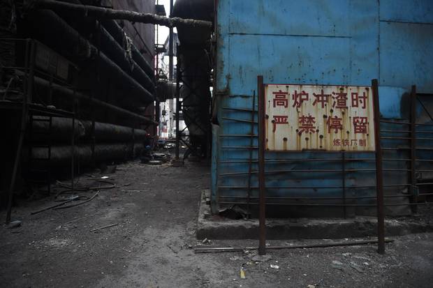 This photo taken on May 28, 2015 shows a sign warning people to stay clear during plant operation at the Shougang Capital Iron and Steel plant in Beijing.