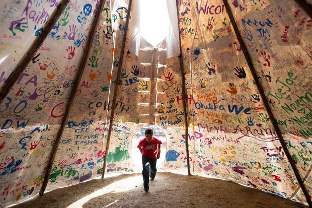 Jesse Jaso, 12, enters the Unity Teepee, at the Sacred Stone Camp near Cannon Ball. Supporters from all across North America and around the world have left signatures and messages on the teepee.