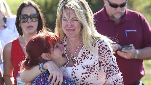 Parents wait for news after reports of a shooting at Marjory Stoneman Douglas High School in Parkland, Fla., on Feb. 14, 2018.