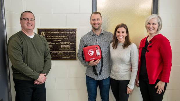 Rich Perverly, centre, visits a school as part of his campaign to raise money to put automatic external defibrillators (AEDs) in schools and to train young people how to use them.