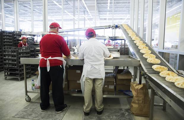Workers pack freshly baked pitas into plastic sleeves at Adonis.