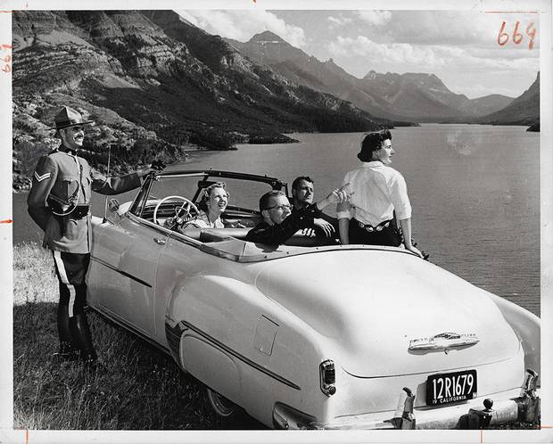 Gar Lunney, [Corporal W.W. MacLeod of the Royal Canadian Mounted Police gives directions to tourists in Waterton Lakes National Park, Alberta], ca. 1958, gelatin silver print.
