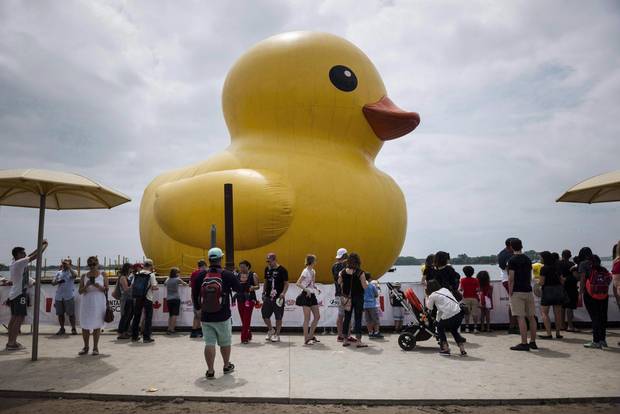 People celebrate Canada Day near the giant inflatable duck on Toronto's Harbourfront on July 1, 2017.