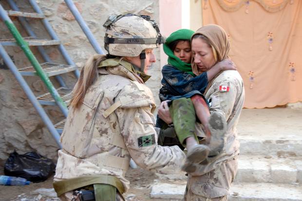 Ms. Le Scelleur (right) tends to a young Afghan girl suffering from a burn at a free medical clinic run by Afghan, Canadian and US medical and dental personnel in Spin Boldak, Afghanistan.
