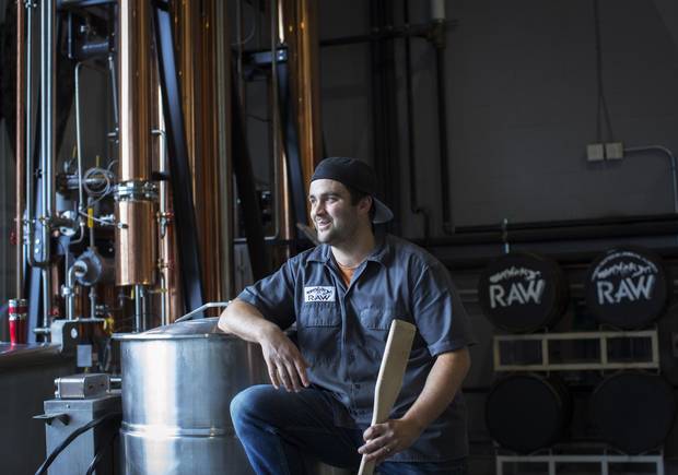 Brad Smylie mixes mash with a paddle at Raw Distillery in Canmore, Alta.