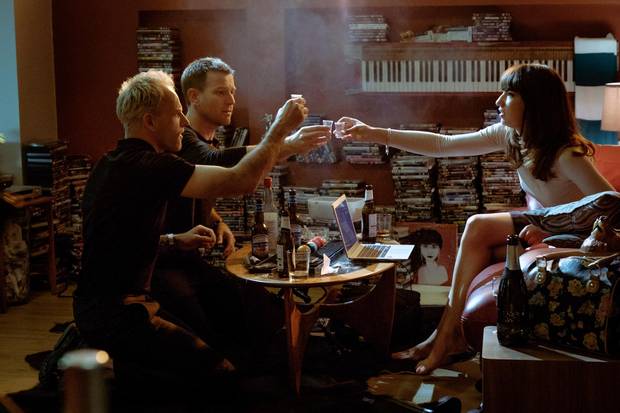 Simon (Jonny Lee Miller), Renton (Ewan McGregor) and Veronika (Anjela Nedyalkova) drinking in Simon's flat in TriStar Pictures' T2 Trainspotting. 
