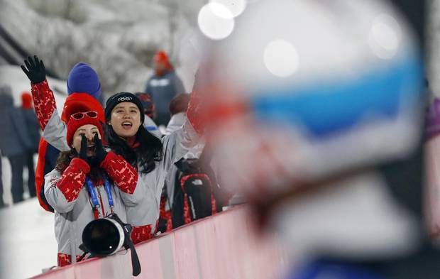 Volunteers cheer for South Korean ski jumper Choi Seou at the Alpensia Ski Jumping Centre in Pyeongchang on Feb. 19, 2018.