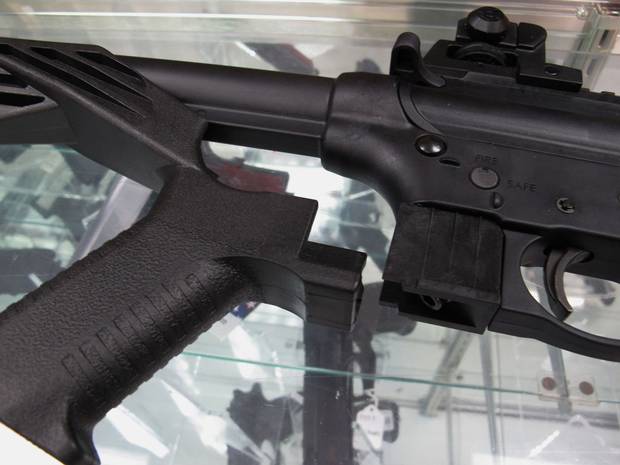 The bump stock, shown at left next to a disassembled rifle.