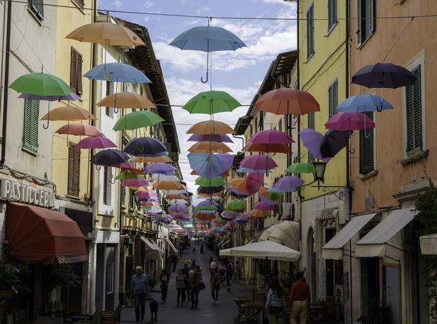 Hundreds of colored flying umbrella colors hang over the Tuscan art town of Pietrasanta.