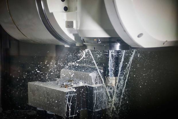 The six-axis drill cuts a part for a V6 engine-block tool. The drill is sluiced with fluid to prevent overheating.