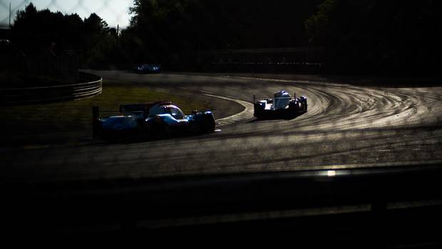 LMP2 cars swing around Indianapolis Corner in the late afternoon.