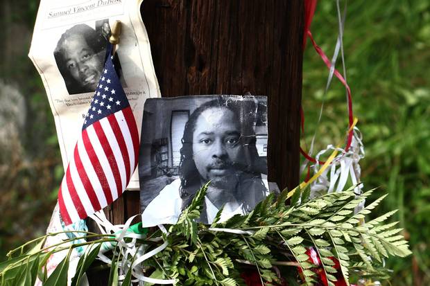 Photos of Samuel DuBose hang on a pole on July 29, 2015, at a memorial near where he was shot and killed.