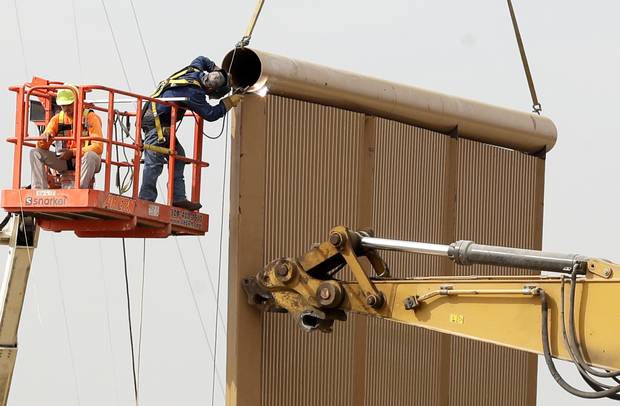 Crews work on a wall prototype near the border with Tijuana, Mexico, Thursday, Oct. 19, 2017, in San Diego.