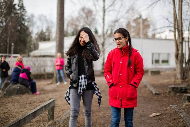 Sabrina Essed, 12, walks with Lara Osman during recess.