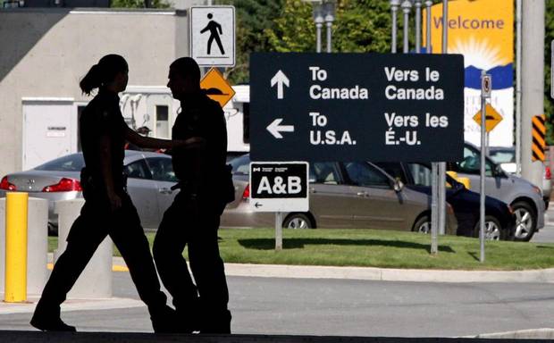Canadian border guards are silhouetted as they replace each at the Douglas border crossing in Surrey, B.C., on August 20, 2009.