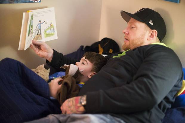 Christopher LeBlanc reads to his son, Maxwell. Mr. LeBlanc shares the same skin condition his son and daughter have.