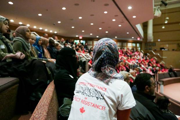 ‘Respect existence or expect resistance,’ reads the shirt of an accomodation advocate at a school-board meeting on April 12.