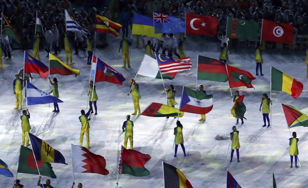 Volunteers hold flags of different countries at the Closing Ceremony in Rio, including Malaysia and Turkey. 