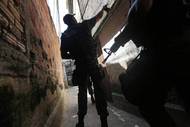 Officers patrol in the Babilonia favela community, which stands on a hillside above Copacabana beach, an Olympic venue site, in Rio de Janeiro on July 26, 2016.