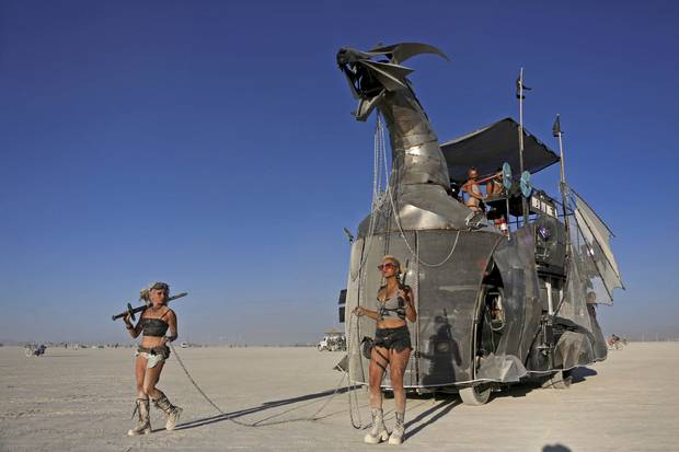Two women escort a mutant vehicle on the playa, Aug. 28, 2017.