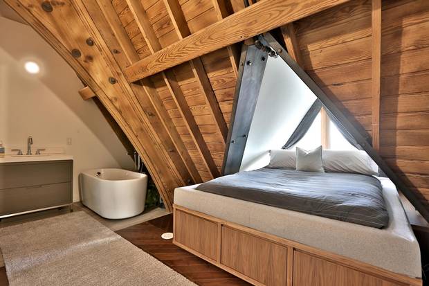 The bed of the master suite sits under a gabled window.