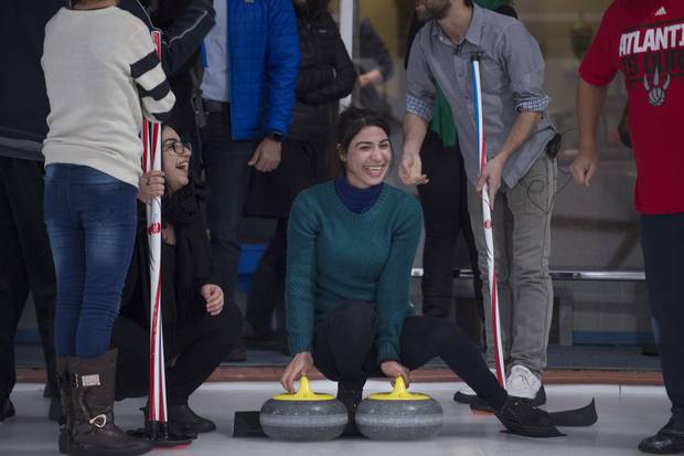 A Yazidi refugee from Kurdistan (centre) is all smiles during an outing to the Royal Canadian Curling Club on Mar 15 2017.