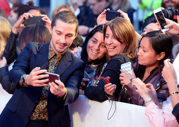 Shia LeBoeuf takes selfies with fans on the red carpet.