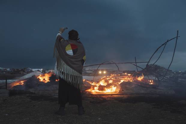 Dawn Of A New Day prays as a wigwam burns on the eve of an Army Corp of Engineers eviction notice at the DAPL resistance camps near Cannon Ball, North Dakota February 21.