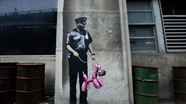 Graffiti from famed British graffiti artist Banksy is displayed on a wall in Toronto on Tuesday, May 11, 2010.