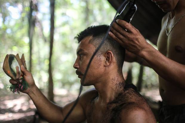 FARC rebel Cristobal, who has been in the guerrilla organization for 15 years, gets a haircut to prepare before watching the peace agreement signing ceremony.