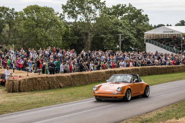 A vintage Porsche races past the Goodwood crowd.
