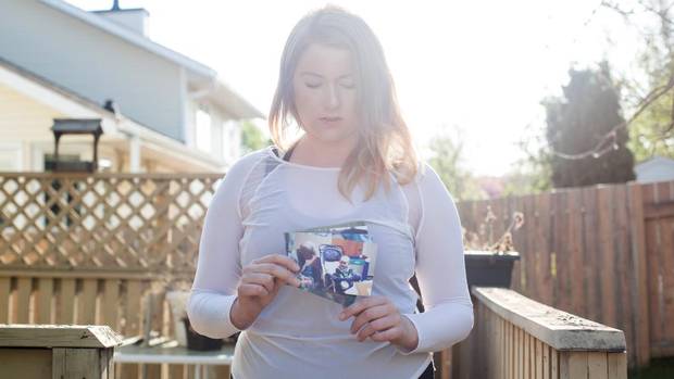 Cassie White, 19, holds one of the only photos of her with her grandpa, now deceased, that she took when she fled the Fort McMurray wildfire.