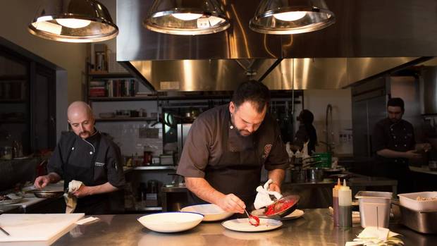 Chef Paul Shufelt plates dishes at his restaurant, Workshop Eatery, in Edmonton.