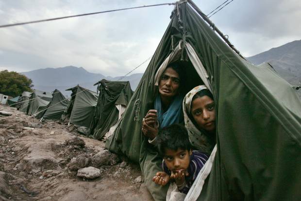 Begum Askar, left, Shaheeda, right, and Waheeda look out from their tent at a relief camp near Kalgie, about 110 kilometres northwest of Srinagar, India, on Oct. 25, 2005.