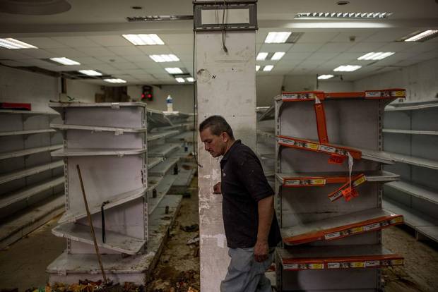 A man walks inside a looted supermarket in El Valle, in west Caracas.