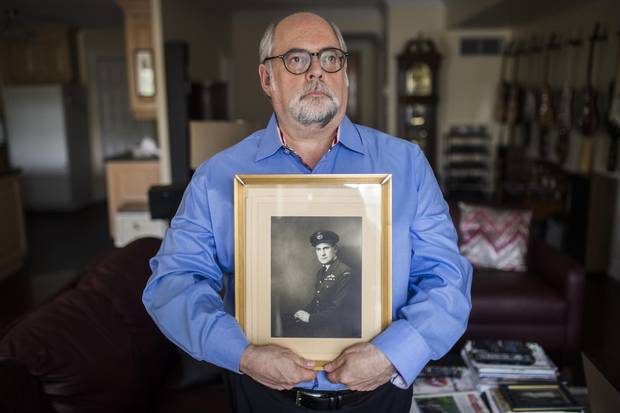 Marc Stevens poses for holding a portrait of his father Peter Stevens, in Toronto, Friday August 4, 2017. Peter Stevens was British air force that was in fact a German-born Jew named Georg Hein, but his mother had sent him to England ahead of the Nazi takeover.