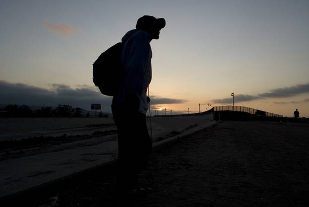 A man planning to cross into the U.S. illegally stands near the dry concrete-lined Tijuana River basin, on the Mexican side of the U.S.-Mexico border in 2008.