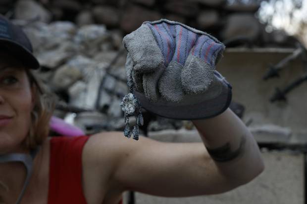 Aja Bulla-Richards, 39, finds jewelry in the ashes of her mothers home in Santa Paula, Calif., Dec. 14, 2017.