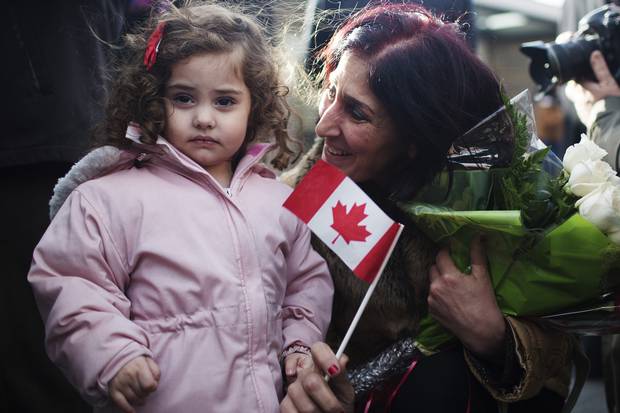 Newly arrived Syrian refugee Elo Manushian, right, is united with her granddaughter Rita Mahserjian, left, in Toronto on Dec. 11, 2015.