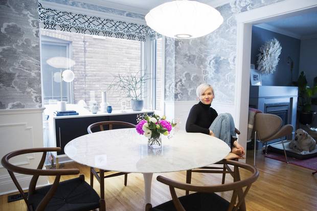 Emilia Wisniewski poses for a photo in her dining room which features Fornasetti Nuvolette wallpaper, a George Nelson saucer crisscross pendant lamp, a Saarinen Marble Tulip Table and Hans J Wegner Wishbone chairs in Toronto on January 9, 2018.