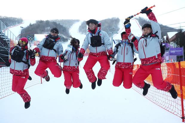 Volunteers pose for a photo after the Ladies' Giant Slalom was postponed due to strong winds on day three at the Pyeongchang Winter Games.