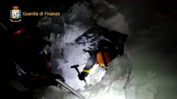 A video image shows rescuers shovelling their way in the avalanche area.