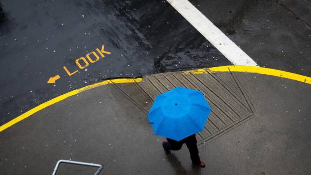 A man carries an umbrella while walking in downtown Vancouver in April 2014.