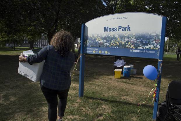 A volunteer carries supplies to Moss Park as the site is set up.