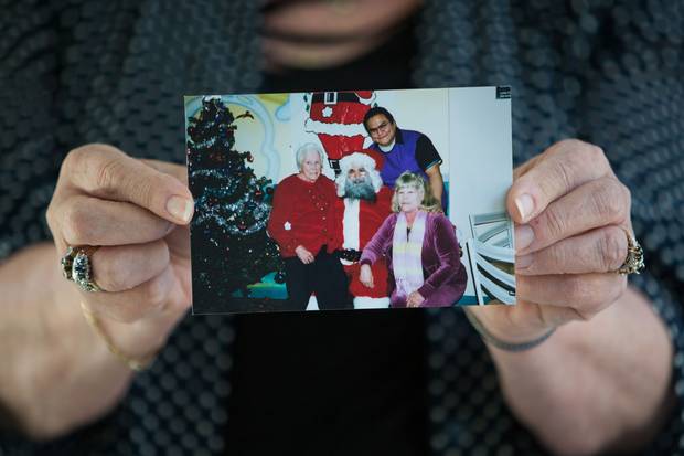 Robyn Batryn holds a Christmas picture of herself, Phillip Tallio and her mother.