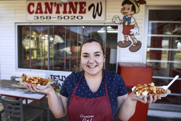 Virginie Gadbois, owner of the Cantine W in Warwick, Que., holds dishes of with poutine outside her restaurant.