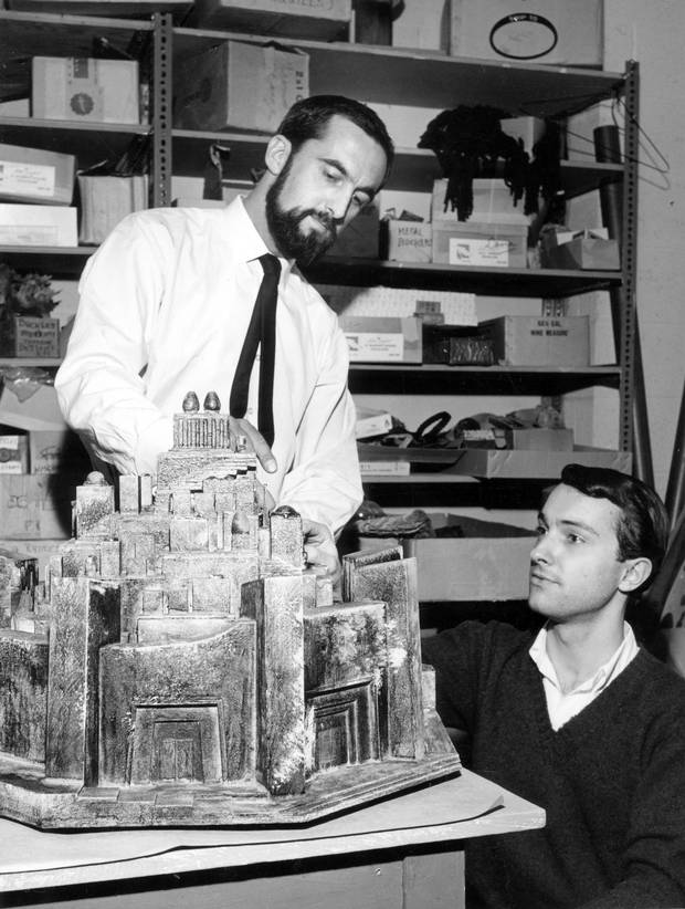 Desmond Heeley, designer of costumes for The Stratford Festival, examines a model of the city of Troy built from his designs for 