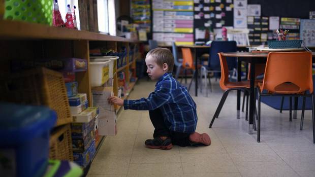 Cameron Taylor, 6, completes his school work as he poses for a photo in his classroom at Mineola Public School in Mississauga on December 21, 2016. He is one of only two Grade 1 English-track students at the school. The rest of his Grade 1, 2, 3 split class is in French immersion.