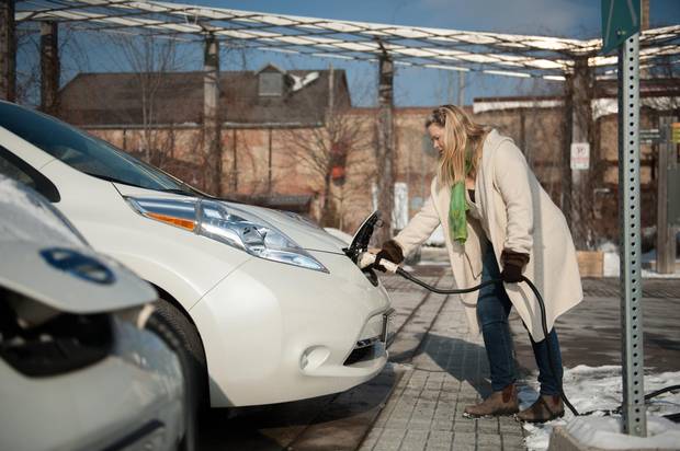 Julia Schindeler charges her electric car, a Nissan Leaf, at a charging station at the Evergreen Brickworks in Toronto.